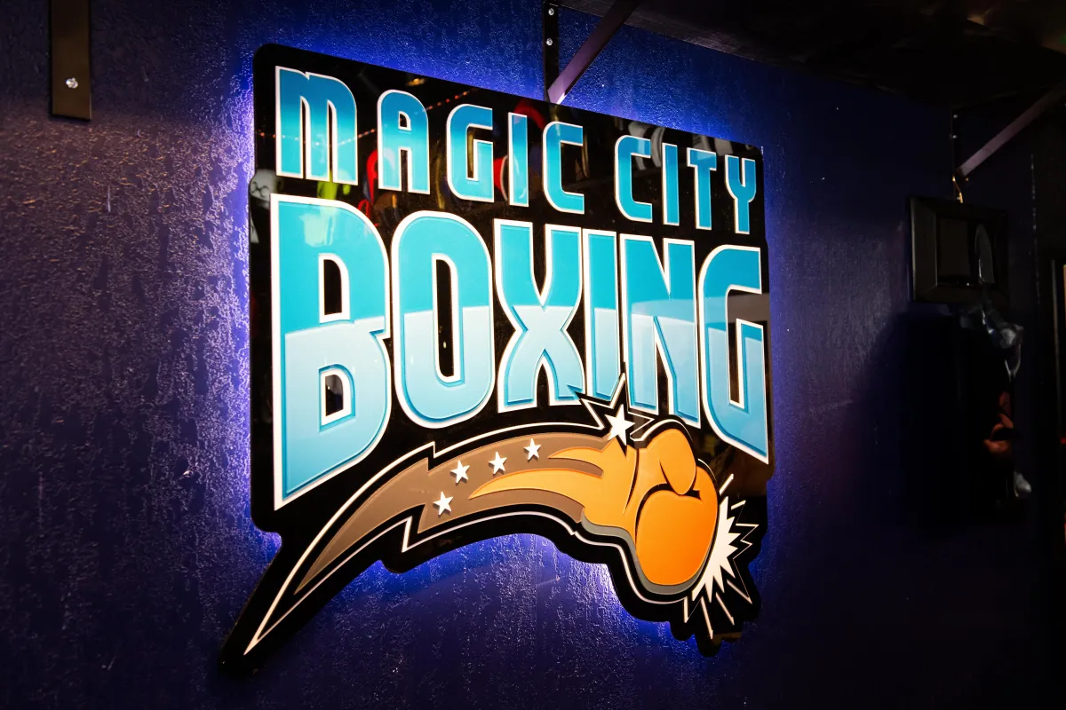 Sideways shot of concentrated serious afro american kid in sports clothes keeping feet on floor<br />